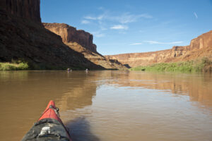 Bow of a kayak descending a river in the desert southwest