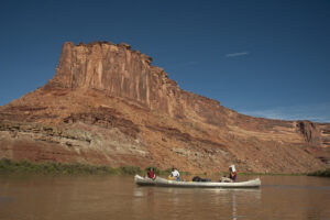 Family canoeing down a desert river in the canyons of Utah