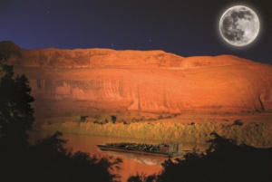 Jet boat floating silently on the Colorado River under a moonlit sky during the Sound and Light Show